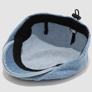Dettaglio del cordino elastico regolabile e fibbia in plastica sul berretto in denim bimbo