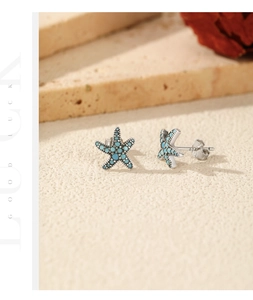 Detailed close-up of S925 sterling silver starfish earrings with blue turquoise inlay