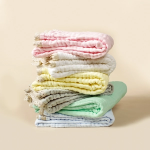 Stack of 6-layer cotton gauze baby blankets with lace trim in pastel colors