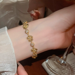 Gros plan d'un bracelet fleur doré avec zircons et texture rayonnante porté au poignet