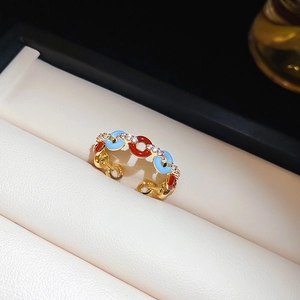 Detailed macro of vintage gold ring featuring colorful enamel and inlaid zircons
