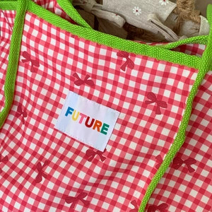 Detail of red checkered tote with green braided trim and Future embroidered patch