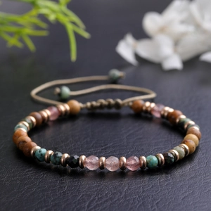 Dettaglio macro del bracciale di pietre naturali con cordino marrone regolabile e oro rosa