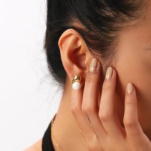 Detailed close-up of 18K gold plated teardrop pearl earrings worn on a female ear