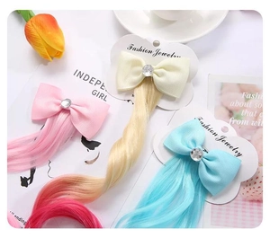 Dettaglio di fermagli per capelli unicorno per bambini con fiocchi colorati e strass