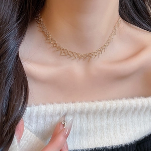 Close-up of golden lace-woven mesh choker necklace with detailed beadwork texture