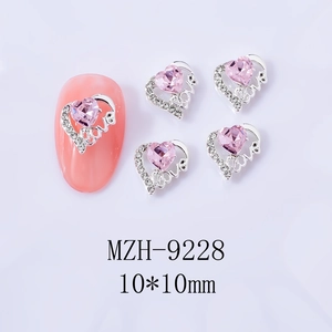 Makroaufnahme der 10mm Nagelkunst-Herzen in Rosa mit LOVE-Metallrahmen und Glitzersteinen
