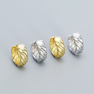 Macro shot of 925 silver hoop earrings with spiral twist texture in gold and silver