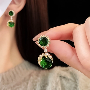 Détail macro de boucles d'oreilles vintage vert émeraude avec perles et dorure