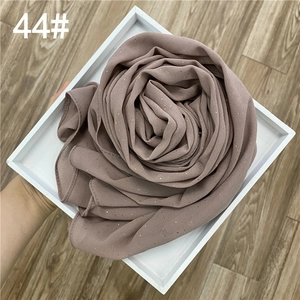 Détail du tissu en mousseline rose poudré avec des paillettes dorées scintillantes