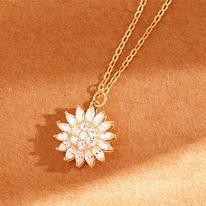 Detailed close-up of a sparkling sunflower pendant necklace with zircon inlay on brown paper