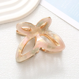 Detail of elegant butterfly hair claw with marble resin and golden metal frame