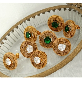 Detail of vintage gold mesh oval earrings with green and white gemstone inlays