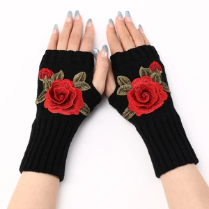 Detail of black fingerless knit gloves with elegant red rose embroidery on the back