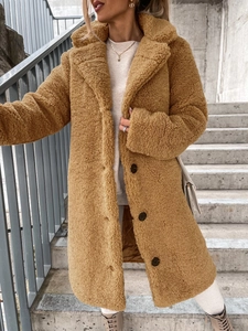 Detailed macro view of plush teddy faux fur texture and lapel on a camel winter coat