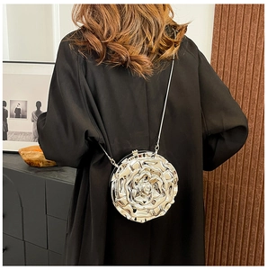 Silver metallic rose-shaped clutch bag with chain strap shown on model shoulder