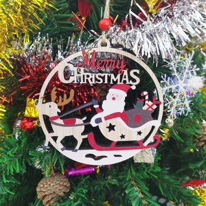 Close-up of wooden Merry Christmas ornament with Santa and reindeer on a tree
