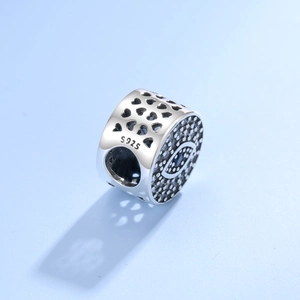 Macro detail of S925 sterling silver evil eye charm with heart cutout patterns