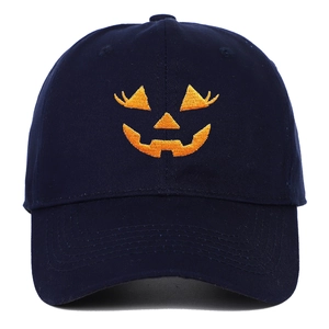 Close-up of bright orange Halloween pumpkin embroidery on navy blue cotton baseball cap