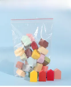 Detailed view of colorful house-shaped makeup sponges in transparent zip bag packaging
