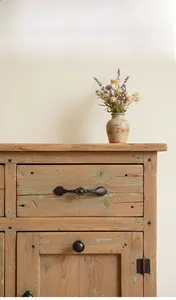 Details von Vintage-Schubladengriffen aus Gusseisen auf einem verwitterten Holzschrank