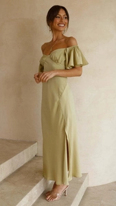 Détail d'une robe élégante en satin vert herbe avec manches volantées et fente latérale