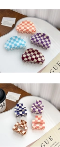 Detail of checkerboard pattern hair claws in various colors on a white display tray