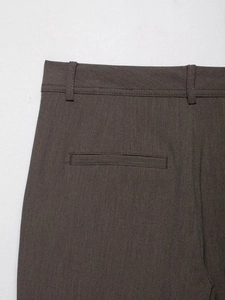 Détail de la taille du pantalon marron foncé avec passants de ceinture et poche passepoilée