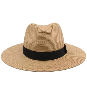 Detail of classic straw fedora with black ribbon band and breathable woven texture