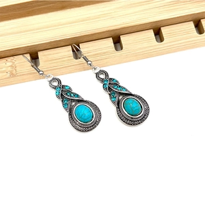 Retro silver bohemian drop earrings with turquoise gemstones on wooden stand
