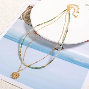 Double-layer handmade beaded necklace with green stones and golden sun eye pendant