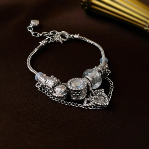 Close-up of beaded DIY bracelet with pavé heart charm and faceted crystal beads