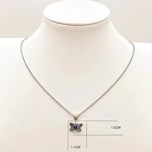 Silver evil eye butterfly necklace with blue stone on a display mannequin