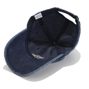 Detailed close-up of blue cotton baseball cap interior with wash label and adjustable buckle