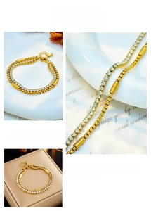 Detail of gold double-layer chain bracelet featuring pavé crystals and cylindrical accents