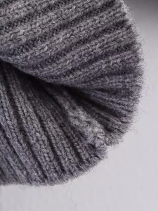 Detailed macro view of dark grey rib-knit fabric texture with soft wool fibers