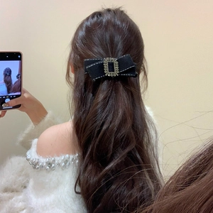 Barrette à cheveux élégante en tissu noir avec boucle en strass sur cheveux bouclés