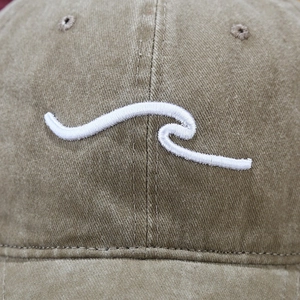 Vue macro de la broderie vague blanche sur une casquette de baseball marron délavé