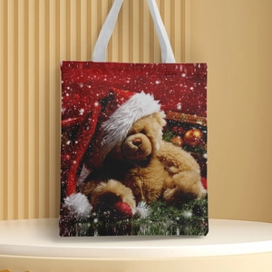 Detail of Christmas teddy bear print on a white canvas handbag with red holiday motifs