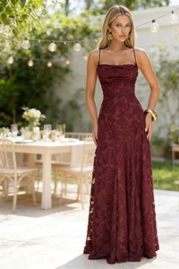 Close-up detail of wine red dress featuring 3D floral texture and elegant strap design