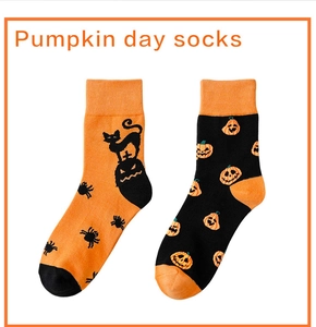 Detail of knit Halloween socks featuring pumpkin, black cat, and spider festive patterns