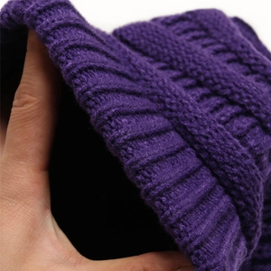 Close-up of purple chunky knit wool hat showing thick ribbed texture and warm material