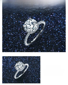 Macro detail of high-shine six-prong round zircon ring on starry blue background