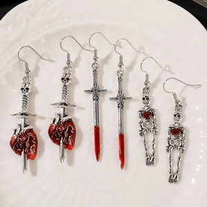 Detailed macro view of Gothic earrings featuring red heart, dagger, and skull designs