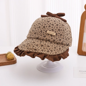 Detailed view of baby girl's floral bonnet with brown bow and corduroy ruffled brim