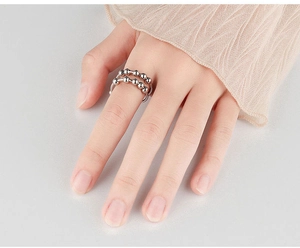 Detailed view of women wearing silver anti-anxiety spinner rings with metal beads