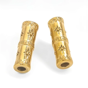 Detailed macro view of golden cylindrical stainless steel beads with star engravings