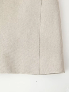 Macro shot of beige twill woven fabric showing precise hemstitching and sewing texture