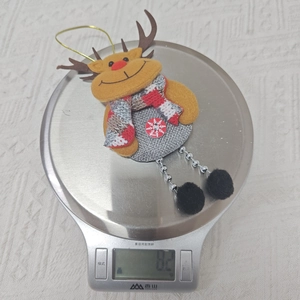 Nahaufnahme von Rentier-Plüschfigur mit Strickschal wiegt 8,2 g auf einer Digitalwaage