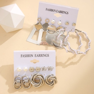 Detail of silver alloy earring set with geometric shapes and imitation pearls on card